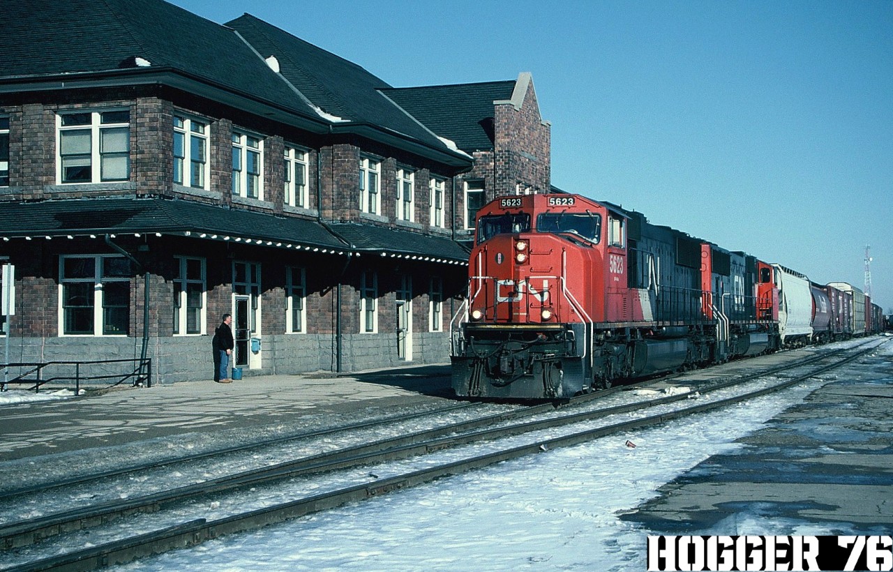 On February 13, 2003, a CN train had derailed almost 30 cars of general freight near Gobles, which sits east of Woodstock, Ontario on the CN Dundas Subdivision. Nearby residents were evacuated because the tankers involved were carrying benzene liquid and petroleum gas. Due to this incident and further complications during the clean-up effort, CN detoured some trains over the GEXR Guelph Subdivision between Georgetown and London over several days. 

My photo here shows an afternoon detour CN train 385 going westbound by the Stratford, Ontario station on the GEXR Guelph Subdivision. The lash-up was CN SD70I 5623 and SD75I 5705.