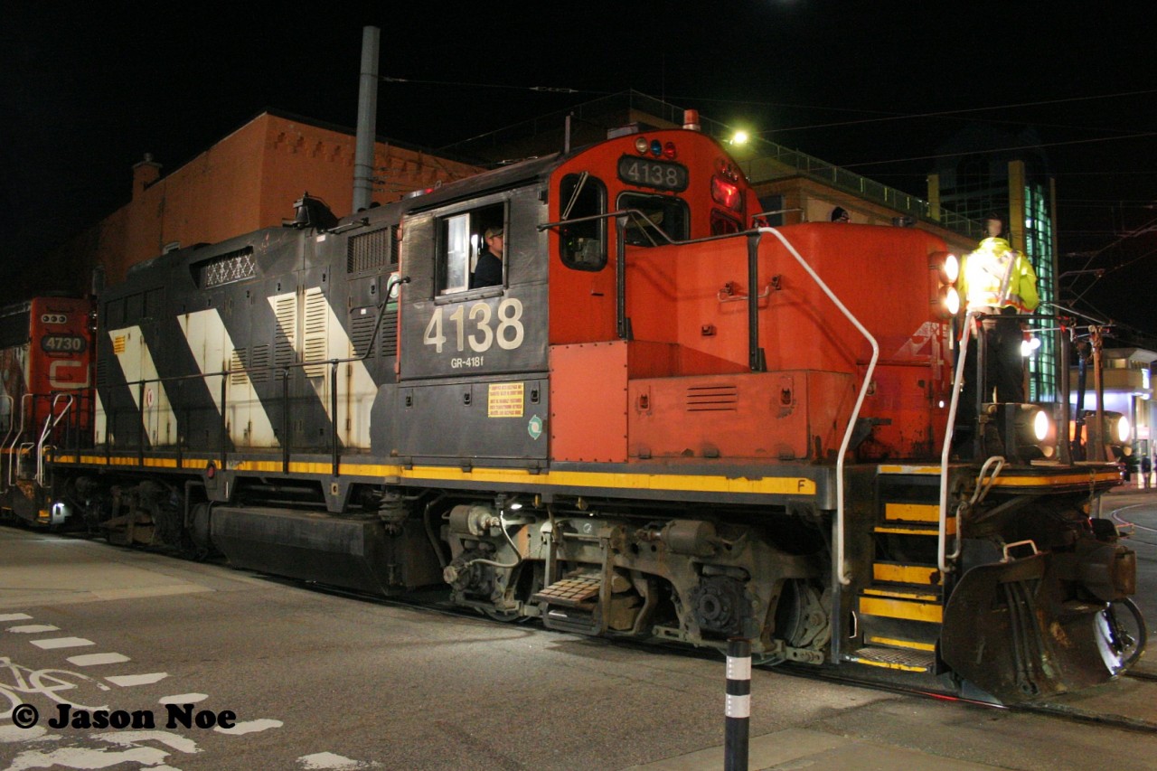 My connection to CN 4138 goes back over 30 years. In July 1993, I had my first cab ride in the GP9RM on the Waterloo Spur, which at the time still had a CN logo on its nose.

Two years after that, it famously had its logo/CN noodle removed and AR Illinois lettering was applied for its role in the Canadian movie “The Wrong Guy,” which was filmed around Toronto and was featured in the train scenes.

In the three decades since my ride, 4138 still occasionally can be found heading to Elmira on the spur, now on Kitchener-based CN L566. Both the GP9RM and the line itself have survived the test of time, however the world around the tracks in Waterloo has been transformed. The downtown core and the former Waterloo Town Square Mall have been altered with the addition of the ION Light Rail network. As well, infrastructure along the spur from King Street to the Northfield Drive area of the city has been modernized to accommodate the light transit corridor. With this addition also came an operational agreement where freight trains could now only operate over this portion of the spur to Elmira between 23:00-05:00 due to the LRT schedule. 

However, there is no better example of time, then on 4138 itself. As the veteran GP9RM emerges through the buildings and onto King Street, it’s fading, and battle-scarred AR Illinois logo is evidence enough. Here, the conductor has just finished protecting the crossing while onlookers and casual bystanders bring out their smartphones to capture it with photos or vids. And just for that moment, 4138 is a star again. 
If someone had told me when I was a teenager that 30 years later, I would still be photographing the same unit on my hometown line, I don’t know if I would have believed them. This likely won’t be the case moving forward as the remaining aging CN GP9RM fleet are in the twilight of their storied careers.
 
For my 1000th post on rp.ca I’ll cross the tracks and step back in time to the summer of 1996 where myself and 4138 were both much younger.