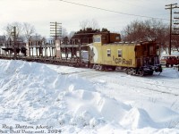 Heading home on snowy Christmas Eve, CP 438717 brings up the rear end of a westbound extra freight as it rolls though the town of Campbellville, the tail end crossing Main Street as the head end approaching or already at Guelph Junction. The open bilevel autoracks in multimark and script are a nice touch.<br><br><i>Reg Button photo, Dan Dell'Unto collection slide.</i>