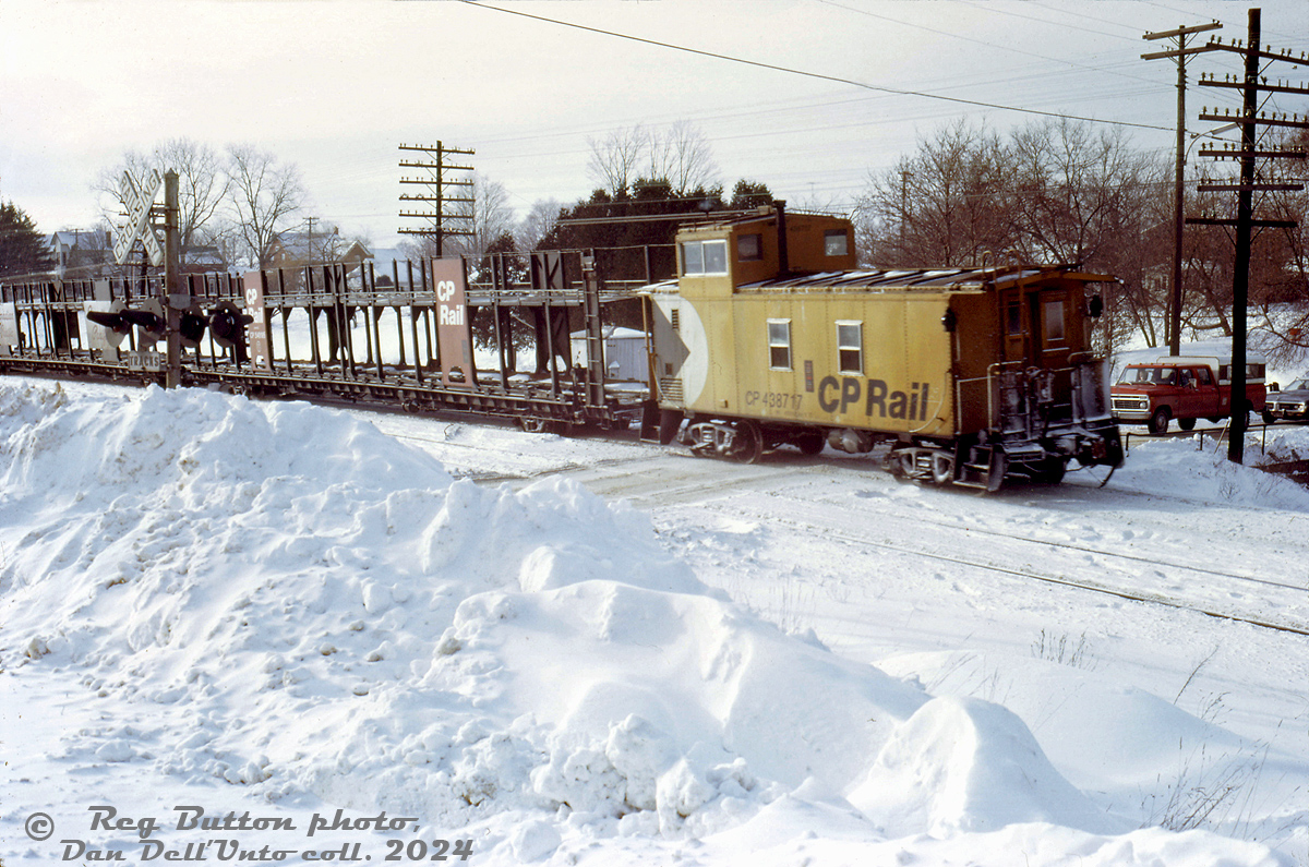 Heading home on snowy Christmas Eve, CP 438717 brings up the rear end of a westbound extra freight as it rolls though the town of Campbellville, the tail end crossing Main Street as the head end is at or approaching Guelph Junction.Reg Button photo, Dan Dell'Unto collection slide.