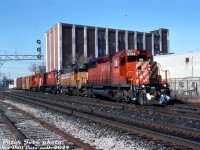 CP SD40-2 5794, leased HATX 215 (a former UP/MP GP38-2), C424 4241 and GP38-2 3075 lead train #934 off the MacTier Sub onto the North Toronto Sub at Osler Street, heading eastbound for CP's Toronto (Agincourt) Yard just before noon.<br><br>The two main tracks of CP's North Toronto Sub are in the foreground, with the track at the bottom left being the old S-Yard lead that curved south and ran along the east side of the rail corridor to serve a small handful of customers between West Toronto to Dundas Street (the <a href=http://www.railpictures.ca/?attachment_id=38483><b>"Old Bruce" TG&B service track</b></a>, now the West Toronto Railpath).<br><br>The signal bridges in the distance bracket the CN-CP West Toronto diamond, near the northern approach of the ill-fated Old Weston Road railway bridge that can be seen in the background (the main span over the tracks having been already removed). And a derailment in the late 2000's took out that large warehouse off Osler Street just behind the power.<br><br><i>Peter Jobe photo, Dan Dell'Unto collection slide.</i>