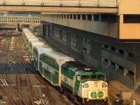 Early worm gets the bird: it's 7:15am, and GO Transit F59PH 541 glints in the morning sun as it pushes its consist out of Union Station. Having come in on Lakeshore East train #425 westbound from Oshawa (6:12-7:12am), it's now operating as equipment move 456 deadheading west empty, to begin train #456's eastbound run on the Lakeshore Line from Oakville station back to Union (7:58-8:21am).
<br><br>
The train has just departed the Union Station train shed, and is ducking under the Metro Convention Centre's pedestrian bridge on the approach to John St. interlocking tower. On the right is the "fence track", used for parking business cars, special passenger equipment and maintenance equipment. Back in the day, railroad executives often parked their private business cars here if they were going into town or staying at the Royal York Hotel nearby.