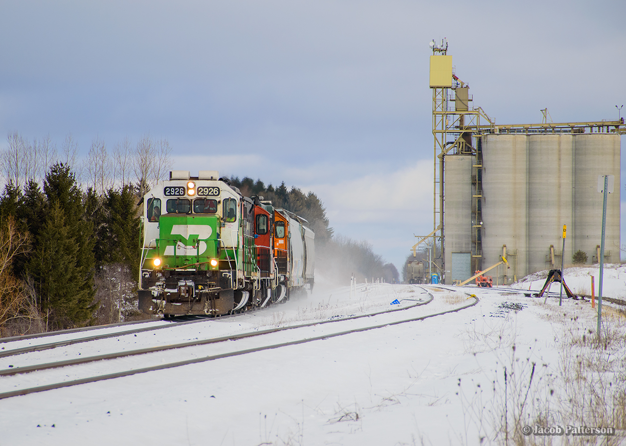 Kicking up the snow on their homeward trip to Kitchener, CN L540 zips past the Parrish & Heimbecker elevator at Shantz with a few hoppers from Traxxside.