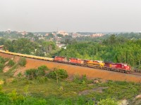 <b>A merging of the eras</b> — Train 421 has finished working Sudbury yard and is now grinding up-grade to the end of the double track at Flanagan. Today's units are very fusion-y, featuring both a CP and (faded) KCS GE product, followed by a couple of multimark SD40-2s with a ballast set. The train is hitting late-evening sun while a thick bed of smoke fills the Sudbury basin in the background; I remember it being difficult to get the colour/light balance right here.