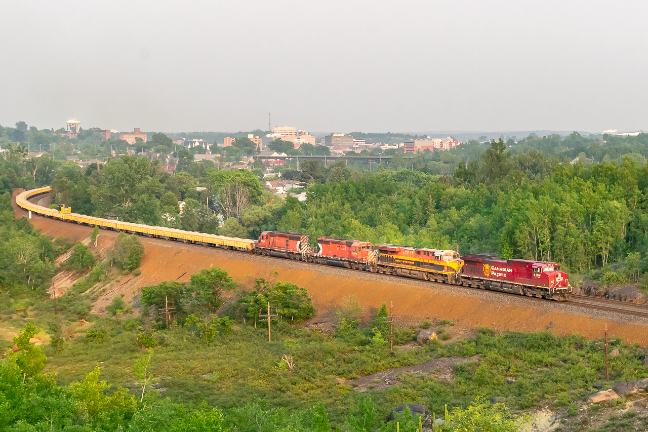 A merging of the eras — Train 421 has finished working Sudbury yard and is now grinding up-grade to the end of the double track at Flanagan. Today's units are very fusion-y, featuring both a CP and (faded) KCS GE product, followed by a couple of multimark SD40-2s with a ballast set. The train is hitting late-evening sun while a thick bed of smoke fills the Sudbury basin in the background; I remember it being difficult to get the colour/light balance right here.