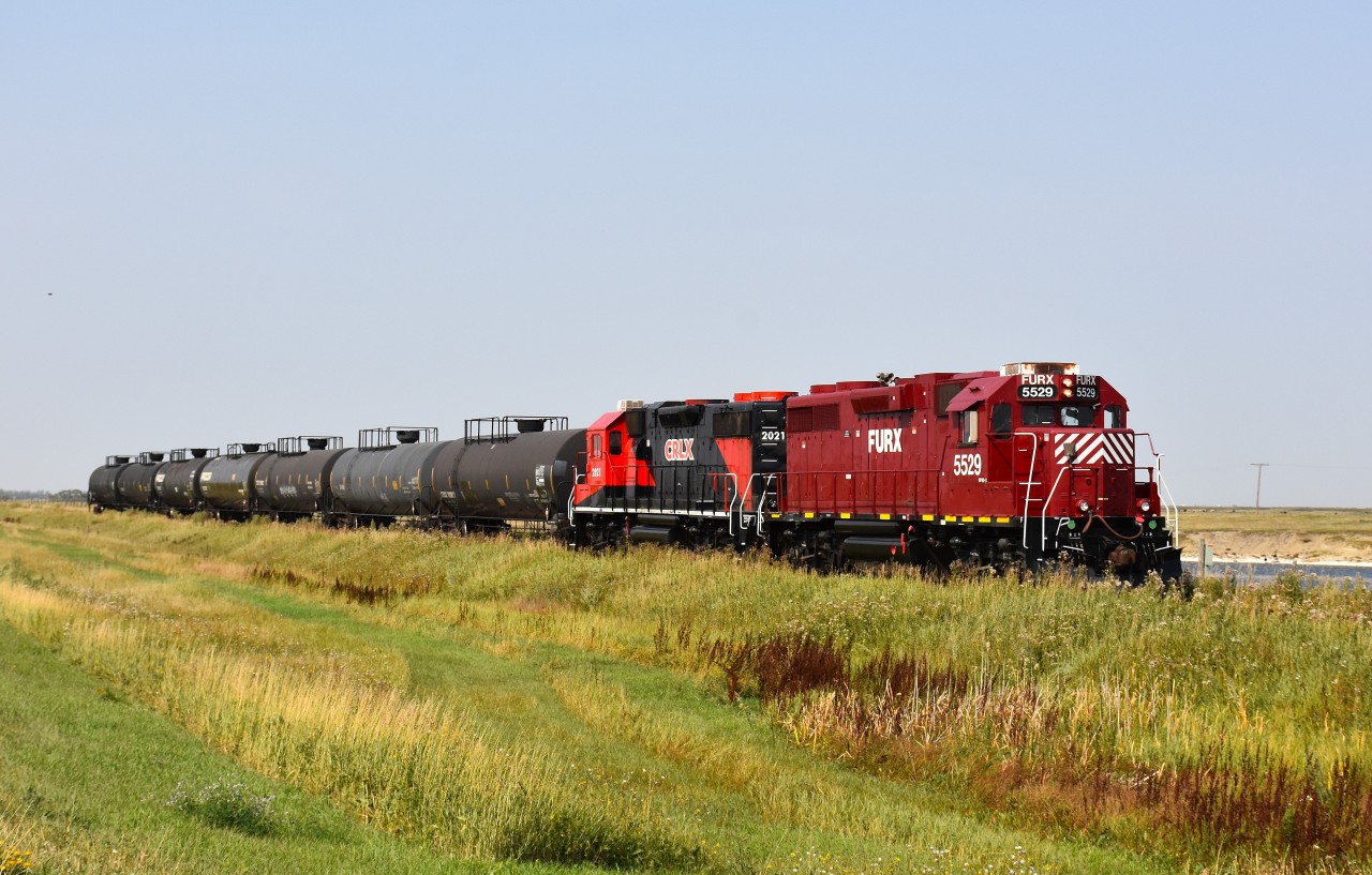 After a rather frustrating day finding not much of anything in this part of lower Saskatchewan, we were quite pleased, while heading north, to meet this southbound on the Stewart Southern Railway. A pair of leased units with 7 tank cars in tow. I have to admit the spiffy clean paint job on both was a bonus as well. FURX 5529 and CRLX 2021, a pair of GP38-2 units is the power. This was actually the first time I had ever seen a locomotive with CRLX (Canadian Railserve) reporting marks....at least one in this paint.    Nice!!