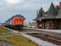 CN Rapido 64 passes through Whitby ducking under Henry Street near the 1912-built station.  Passenger service to this station ended in 1969, with it being relocated in 1970 by a group of local artists to the corner of Henry and Victoria Streets, just south of its original location.  In 2004 it would be moved again, just across the street where <a href=https://images.squarespace-cdn.com/content/v1/629a1faa2dfa452a23413749/1654705732392-2N51U7D0IQA6K4GGUFXF/ezgif.com-gif-maker+%285%29.jpg?format=1500w>it remains today.</a>

<br><br><i>Scan and editing by Jacob Patterson.</i>