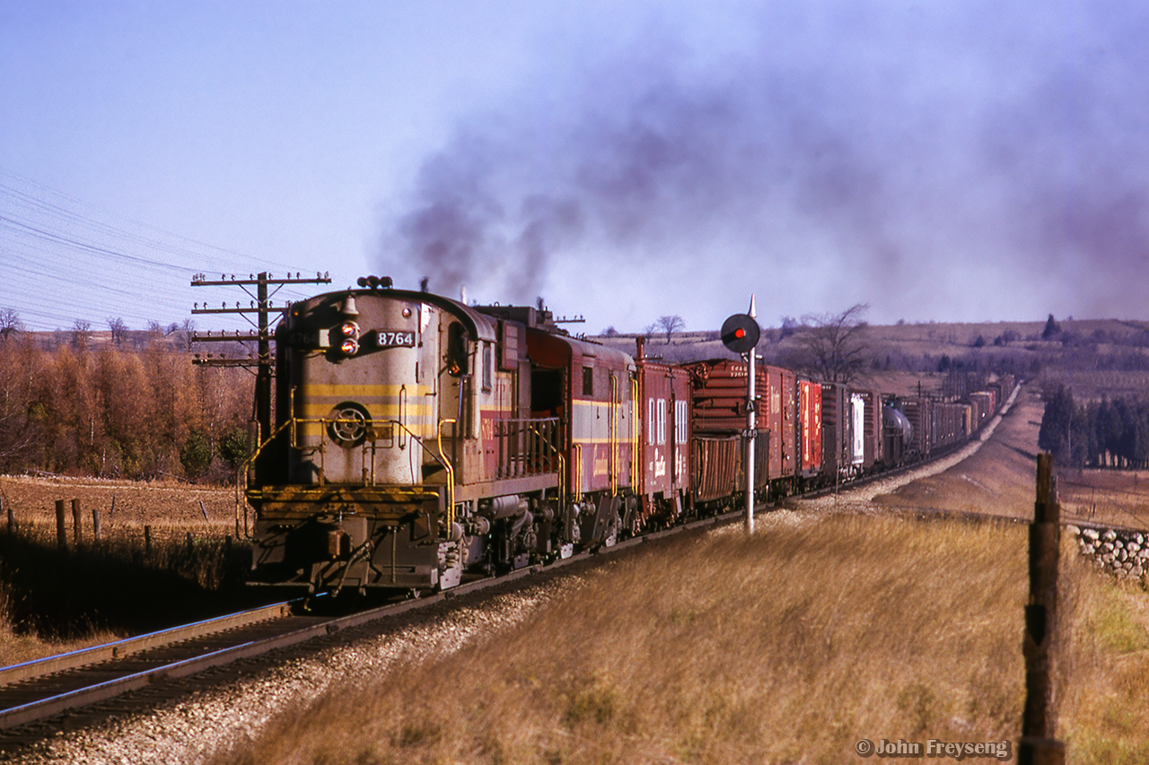 CPR Extra 8764 west climbs the grade approaching the Highway 6 overpass at Puslinch.

Scan and editing by Jacob Patterson.