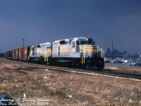 Freshly minted from the GMD London assembly plant, brand new Quebec, North Shore and Labrador SD40 units 200 and 205 are out on a test run on Canadian Pacific, seen at what appears to be the east end of CP's Windsor Yard at Tecumseh Street. The "storm lighting" in this photo is rather captivating, with part of the Detroit skyline looming in the shadows in the distance.
<br><br>
Both units were part of a six-unit SD40 order (QNS&L 200-205) built in February-March of 1969 by GMD. Iron ore hauler QNS&L at that time had a roster of mainly GMD GP7 and GP9 locomotives built in the 1950's, so this order was their first 6-axle high horsepower second-generation diesel purchase. They would place another order in 1971 (206-220), and SD40-2 orders in 1972, 1973 and 1975, retiring a lot of their early Geep fleet (a good number were sold to <a href=http://www.railpictures.ca/?attachment_id=52282
><b>Bellequip</b></a> and later <a href=http://www.railpictures.ca/?attachment_id=52259><b>Precision National</b></a> for lease service in the early 70's).
<br><br>
200 would later be retired and rebuilt as KCS 696, while 205 would become CP 5401.
<br><br>
<i>Harry L. Juday photo, Dan Dell'Unto collection slide</i>