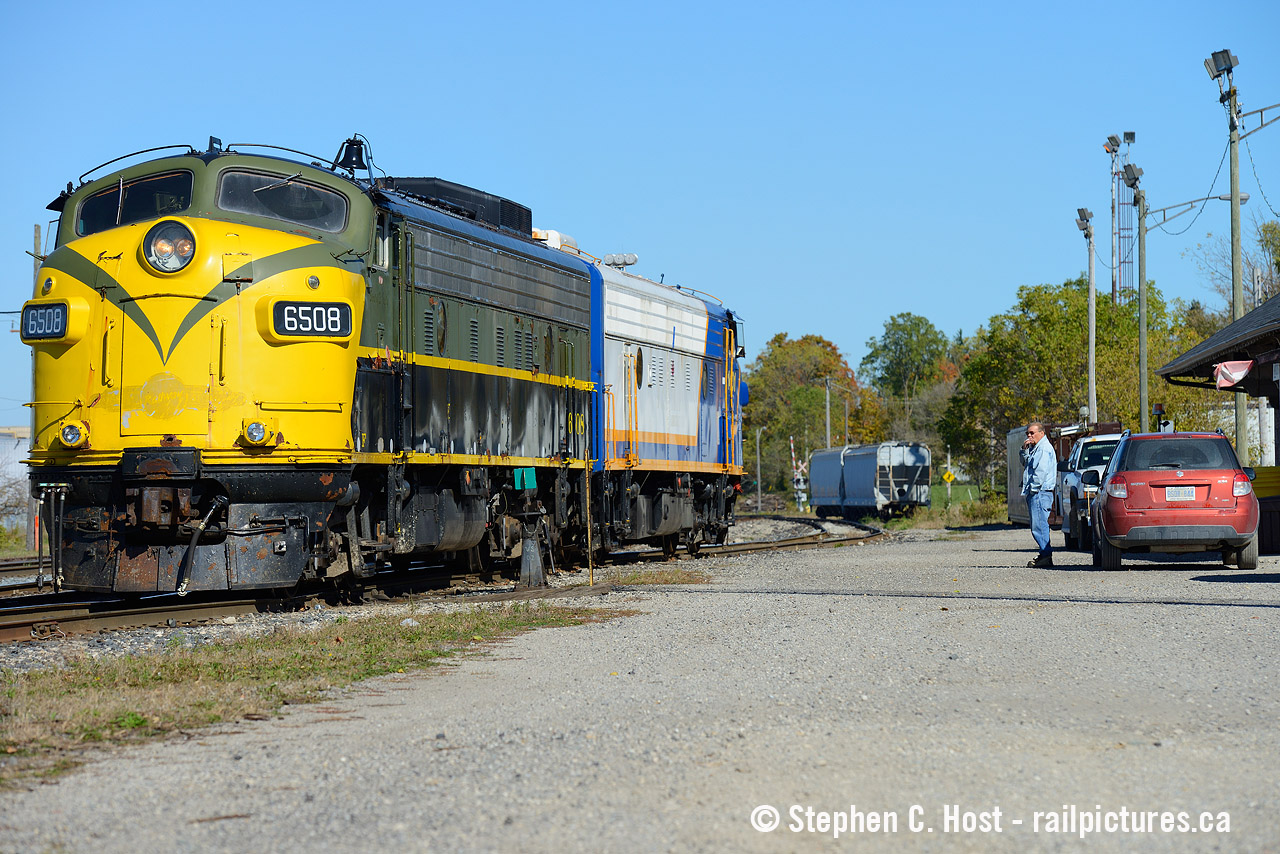 The Man, the myth, the Legend - This was 10 years ago when I was younger and my photography shows it, but here's some of the human  side of railroading. I bet many folks will browse by this image and go "oh another shot of some OSR F units, there's so many shots of these" but this isn't any ordinary subject matter. Those who know know right away who that is at right: OSR Founder and President Kenneth (Jeff) Willsie taking a giant puff of a cigarette while watching his F units park for Lunch at the CP Woodstock Station. Jeff's red Suzuki Swift is parked at right with Jeff's handprints all over the trunk as he would have to get in there to grab his radio or safety vest, if he chose to wear one. Jeff's wearing the classic Canadian Tuxedo on this fine October day while a Canadian flag flaps in the breeze at the station. The folks at OSR already had paint in mind for 6508 and by the next summer it would be in OSR paint. Jeff was always friendly and I saw him so often in this era watching his F units work, sometimes he was even in the Engineer's seat. What's your favorite memory of Mr. Willsie? Please add a comment below.