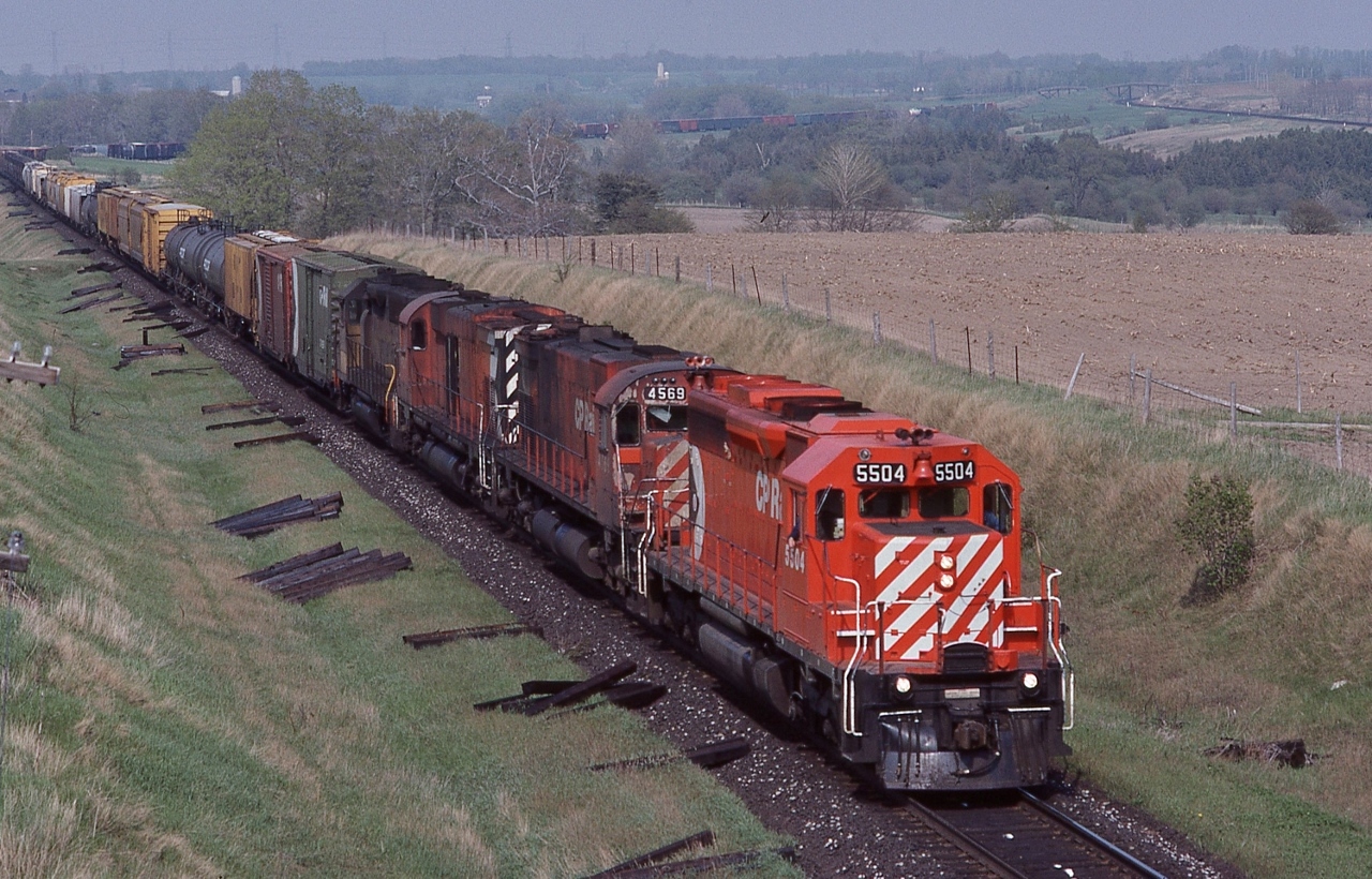 A common motive power practice, a CP Rail SD leading a pair of big M's.


Second #927,  through the Northumberland hills, on the grade approach Lovekin. 


On a glorious spring day, at the Newtownville overpass, May 11, 1985 Kodachrome by S.Danko


Power: #5504   - #4569 – #4727 – and a ubiquious Chessie. 


And in the distance, the pair of 'bee bridges' a k a Nichol's road overpasses