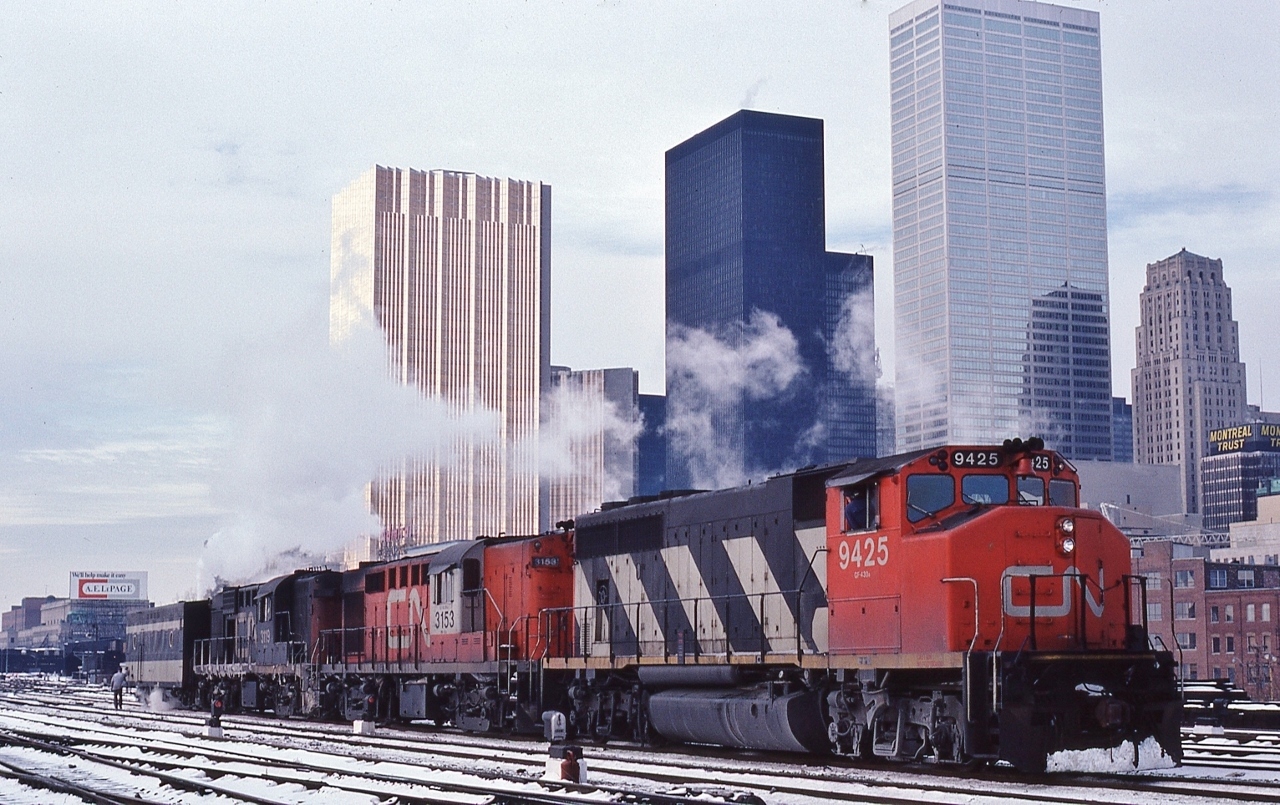 Christmas season creates interesting consists...


The Engineman is awaiting the light controlled by the TTR Scott Street Leverman,


with an all CN lash up, likely off a Windsor VIA train, (unlikely a 9500 series would lead on the Kingston Sub)., 


Given three units plus a steam generator, the conventional consist had to be 13 plus cars....


GMD 1974 built GP40-2L(W), CN #9425, geared for 65 mph


MLW 1960 built RS-18m (modified circa 1967 for Tempo service) CN #3153, geared for 80 mph


MLW 1959 built RS-18, CN #3113, geared for 80 mph


At TTR Jarvis Street, December 28, 1980 Kodachrome by S.Danko