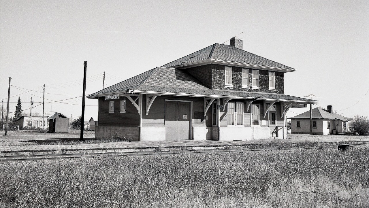 Among the maze of grain-gathering branchlines between Prince Albert and North Battleford was CN’s Robinhood sub., timetable westward from Speers Jct. through to Medstead then Glaslyn, and around the midpoint was Rabbit Lake, with its depot seen from the west end and in well-maintained condition on Saturday 1976-10-09.