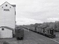 Fourteen miles east of the Rabbit Lake depot photo posted a week ago, and five years later, the hamlet of Mayfair experienced the passage of CN 1046 + 1036 and a long train of grain boxcar loads collected on a Loop Job assignment out of North Battleford, via the Blaine Lake sub. to Amiens Jct., then swinging westward on the Amiens sub. to Medstead, southward on the Robinhood sub. to the Blaine Lake sub. at Speers, then westward via Denholm to home terminal North Battleford.

<p>In following that route on a map some years later, I learned that the tail end of that train was very close to where there had been a diamond crossing of CP’s Whitkow sub. (around GPS 52.98752, -107.60351) on its way east to Ravenhead, a line with minimal photographic evidence east of Redfield.