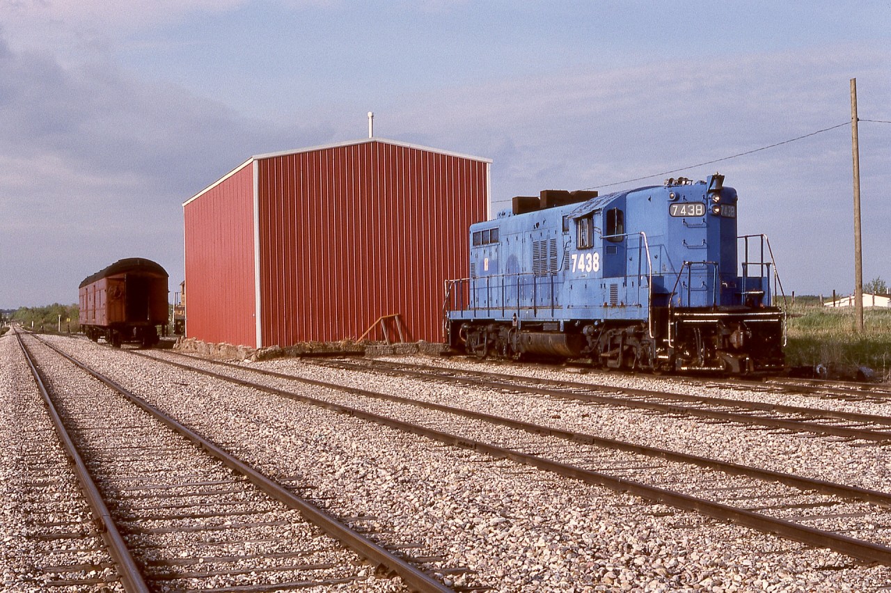 For locomotive maintenance needs, Central Western Railway had a shed (door at other end) at Warden, 5.2 miles south of operations headquarters at Stettler.  On Friday 1990-05-25, GP9 7438 (ex Conrail 7438, ex Penn Central 7438, nee New York Central 6038), with magnificent and distinctly different exhaust spark arrestors, awaited its next duty.