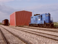 For locomotive maintenance needs, Central Western Railway had a shed (door at other end) at Warden, 5.2 miles south of operations headquarters at Stettler.  On Friday 1990-05-25, GP9 7438 (ex Conrail 7438, ex Penn Central 7438, nee New York Central 6038), with magnificent and distinctly different exhaust spark arrestors, awaited its next duty.