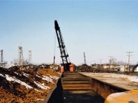 Mountains of Pig Iron sit on the east banks of the Welland Canal inside the property of the Canadian Furnace Company - Algoma Steel Corporation.  At the time the photo was taken the plant had been idle for 4 years but was on "cold" standby waiting for a call to re-start that never came.  One of this plants main customers was the 185,000 sqft. Massey-Ferguson "M" foundry (Grey Iron) in Brantford, ON.  In the distance you can see the scrap piles of the DWOR Metal Company, Bridge 20 (rail) and Bridge 21 (Auto) over the canal.  This location has been earmarked to be a new 33M CAD Great Lakes Bio-Fuel storage facility, maybe rail will go back in ?!? Thanks to Steve H for help on this one.