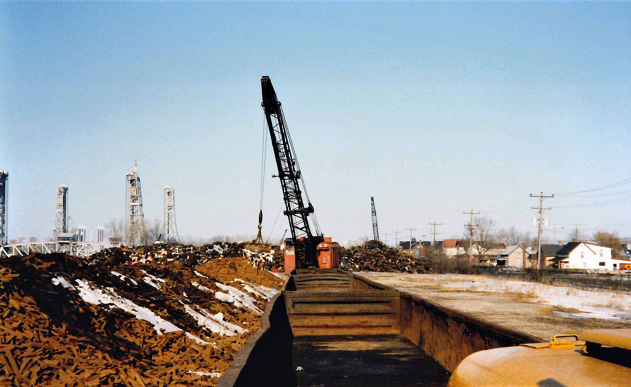 Mountains of Pig Iron sit on the east banks of the Welland Canal inside the property of the Canadian Furnace Company - Algoma Steel Corporation.  At the time the photo was taken the plant had been idle for 4 years but was on "cold" standby waiting for a call to re-start that never came.  One of this plants main customers was the 185,000 sqft. Massey-Ferguson "M" foundry (Grey Iron) in Brantford, ON.  In the distance you can see the scrap piles of the DWOR Metal Company, Bridge 20 (rail) and Bridge 21 (Auto) over the canal.  This location has been earmarked to be a new 33M CAD Great Lakes Bio-Fuel storage facility, maybe rail will go back in ?!? Thanks to Steve H for help on this one.