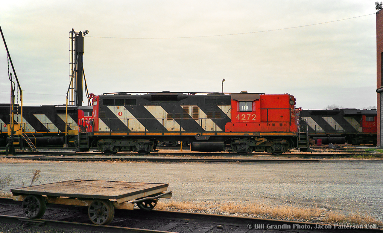 A number of CN units sit outside the diesel shop at Fort Erie, with GP9 4272 front and center.  SD40-2W 5351 and GP40 9302 are also visible, with GP9s 4528, 4276, and SD40-2Ws 5358, 5362 out of frame.

Bill Grandin Photo, Jacob Patterson Collection Negative.