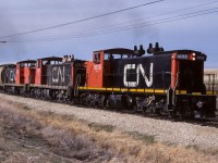 An extra going back to Edmonton with a few loads of grain and some empty tanks. Photo taken at mile 12.7 just south of Gibbons. The train was ascending the last of the hill up from the Sturgeon river. The valley can be seen to the left of the hoppers. In less than a 1/2 mile, the track straightens out and goes directly south to the junction switch.