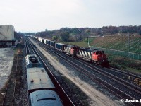 CN SD40-2(W) 5354 and GP40-2L(W) 9631 are viewed bringing an eastbound into Aldershot Yard on the Oakville Subdivision. To the left, VIA Rail train 73 is departing the Aldershot station for the Dundas Subdivision with 6457 west. 