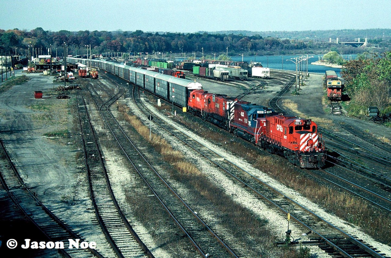 During fall 1994, railway crews were performing extensive undercutting work at CP’s Hunter Street tunnel in Hamilton, Ontario to reduce the actual tunnel’s floor. At the time this work was in preparation for future upcoming GO Transit service through the tunnel and into the city’s downtown. This project resulted in CP detouring some trains over the CN Grimsby Subdivision between Hamilton and Niagara Falls from October 29 to November 1. One of the trains detoured was the Ringling Bros and Barnum & Bailey “Red” Circus train on October 31, which was powered by CP SD40 5550 and SD40-2 5478.

On the morning of October 29, my friends and I were doing our usual rounds in Hamilton, when we heard CP 1817 on the scanner getting a clearance on the CN Grimsby Subdivision. At the time we had no idea about the detour trains or the work being done on the tunnel. Luckily, we weren’t far from Stuart Street, so we made a beeline for the bridge over the yard. Upon our quick arrival, we saw the small crowd of local railfans already gathered there waiting for the CP train. They then gave us the details on what was happening as they were already well informed. Here, CP Toronto-Niagara Falls manifest #526 is viewed passing through CN’s Stuart Street Yard with CP 1817, HLCX 3110, CP 4704 and CP 1843 heading to Niagara Falls.