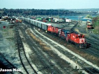 During fall 1994, railway crews were performing extensive undercutting work at CP’s Hunter Street tunnel in Hamilton, Ontario to reduce the actual tunnel’s floor. At the time this work was in preparation for future upcoming GO Transit service through the tunnel and into the city’s downtown. This project resulted in CP detouring some trains over the CN Grimsby Subdivision between Hamilton and Niagara Falls from October 29 to November 1. One of the trains detoured was the Ringling Bros and Barnum & Bailey “Red” Circus train on October 31, which was powered by CP SD40 5550 and SD40-2 5478.
<br>
On the morning of October 29, my friends and I were doing our usual rounds in Hamilton, when we heard CP 1817 on the scanner getting a clearance on the CN Grimsby Subdivision. At the time we had no idea about the detour trains or the work being done on the tunnel. Luckily, we weren’t far from Stuart Street, so we made a beeline for the bridge over the yard. Upon our quick arrival, we saw the small crowd of local railfans already gathered there waiting for the CP train. They then gave us the details on what was happening as they were already well informed. Here, CP Toronto-Niagara Falls manifest #526 is viewed passing through CN’s Stuart Street Yard with CP 1817, HLCX 3110, CP 4704 and CP 1843 heading to Niagara Falls. 
