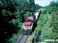 Ontario Southland Railway RS18 183 south arrives in Tillsonburg, Ontario with a small train from the CP interchange at Ingersoll. The train is going under the classic “telltail” on the Tillsonburg Spur (former CP Port Burwell Subdivision). Built with a low nose in 1968, RS18 183 is ex-INCO 208-3. The view was from the now abandoned Caso Subdivision, which crossed over both the CP Port Burwell Subdivision and CN Burford Subdivision at this location. 