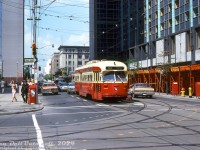 TTC PCC 4463 (A7-class, CC&F 1949) sports fresh "subway red" paint as it pauses for the light eastbound on King Street West at York Street in downtown Toronto. <br><br>In the background is the busy University Avenue (with a westbound PCC waiting on the light. On the right is the Lord Simcoe Hotel, under demolition by Teperman. The Lord Simcoe opened in 1956 at King & University, but according to sources, it was closed in 1979 due to a lack of convention space and central air conditioning making the hotel uncompetitive. Demolition took place in 1980-81.<br><br>Original photographer unknown (may be a Charles Houser photo), Dan Dell'Unto collection slide.