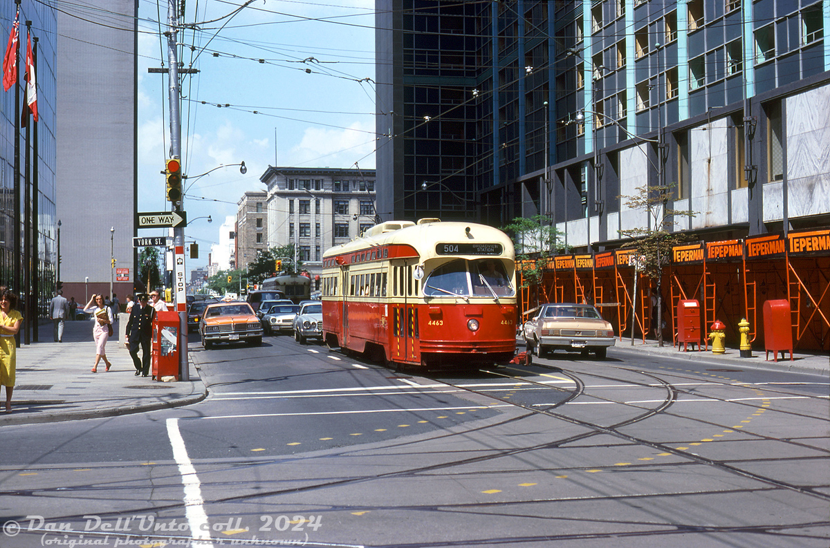 TTC PCC 4463 (A7-class, CC&F 1949) sports fresh "subway red" paint as it pauses for the light eastbound on King Street West at York Street in downtown Toronto. 

In the background is the busy University Avenue (with a westbound PCC waiting on the light. On the right is the Lord Simcoe Hotel, under demolition by Teperman. The Lord Simcoe opened in 1956 at King & University, but according to sources, it was closed in 1979 due to a lack of convention space and central air conditioning make the hotel uncompetitive. Demolition took place in 1980-81.

Original photographer unknown (may be a Charles Houser photo), Dan Dell'Unto collection slide.