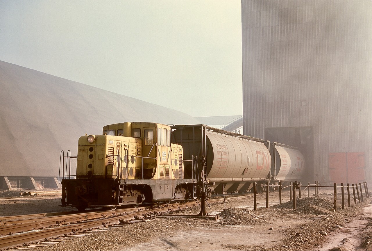 One of numerous potash mines in the area, International Minerals and Chemicals had their K-1 mine conveniently between CP’s Bredenbury sub. fourteen miles to the north at Bredenbury and CN’s Rivers sub. two miles to the south at Yarbo.  On Tuesday 1976-10-05, thirty-five year old GE 13095 44-tonner IMC 1243 was spotting hoppers through the K-1 potash loadout.