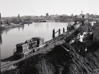 Canadian National’s Cowichan subdivision on Vancouver Island was separated by bridge conditions, so traffic from the mainland arrived Victoria via barges to a slip at Point Ellice just below the Bay Street road bridge.  On Tuesday 1978-12-05, yard engine CN 1002 was switching self-propelled rail barge SEASPAN GREG, with evidence of cold-weather extensive idling drooling down the sides of the engine hood.

<p>On the other side of the harbour, directly above 1002, is another rail barge slip, that one for serving the Victoria Machinery Depot’s facility.