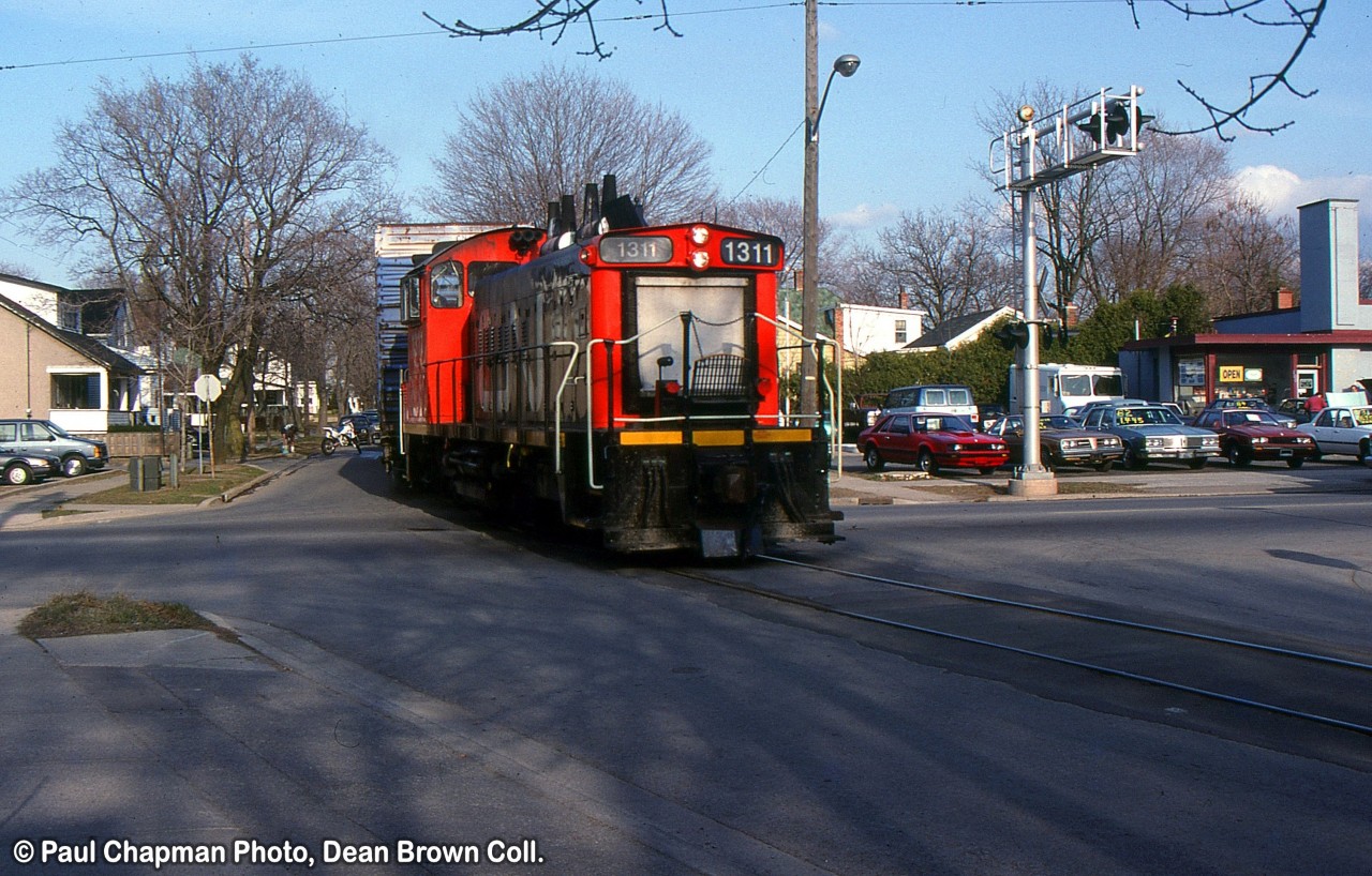 CN 551 with CN SW1200RS 1311 on Louisa St. crossing Lake St.