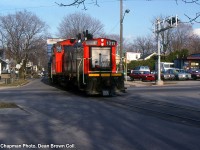 CN 551 with CN SW1200RS 1311 on Louisa St. crossing Lake St. 