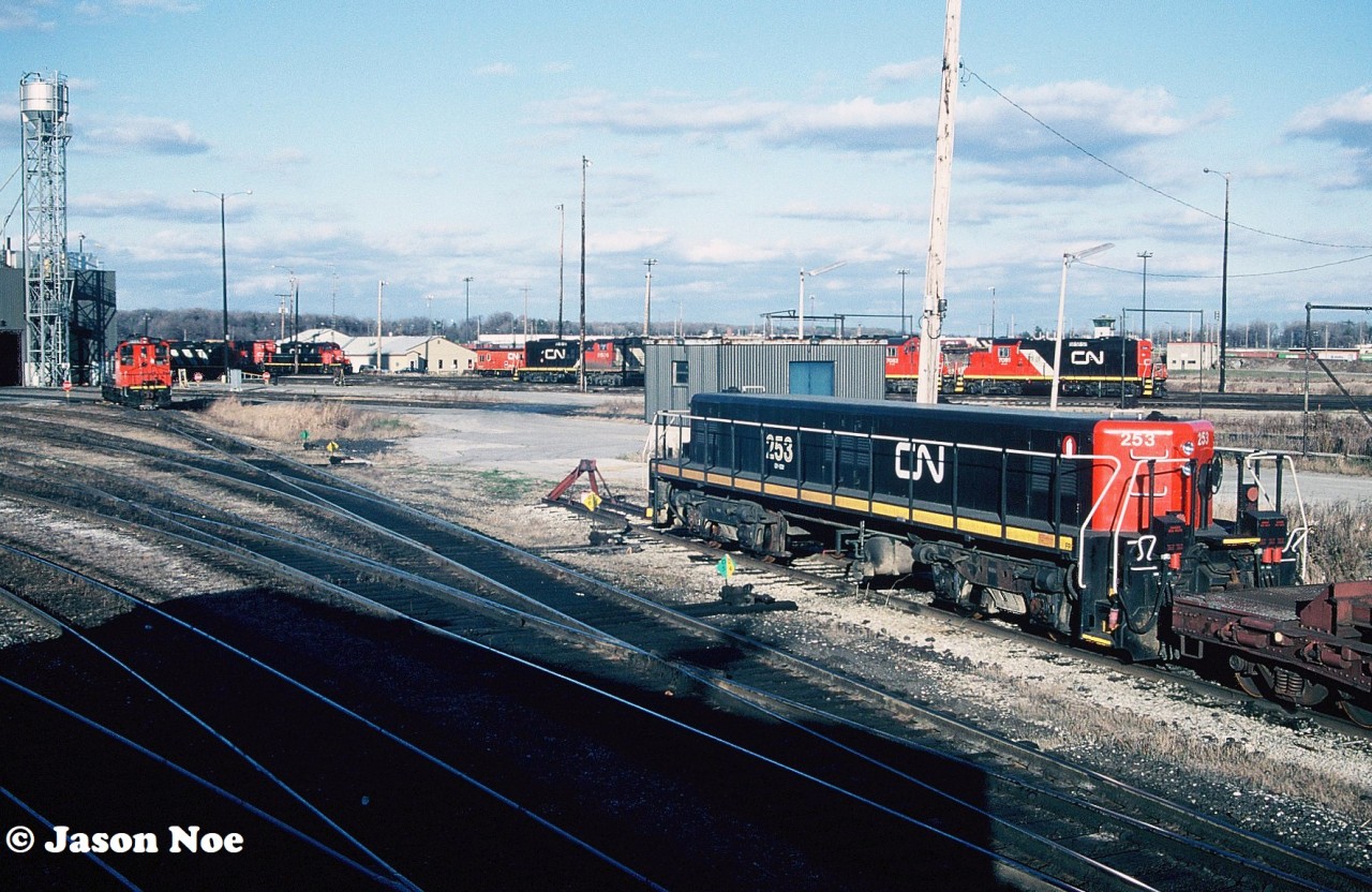 While touring around CN’s MacMillan yard diesel shop one November afternoon we stopped to photograph M-420(W) 3507, which had just emerged from one of the bays.  A young hostler helper was busy closing engine compartment doors and doing some other inspections, when he spotted us below. “Hey, you guys wanna come up for a ride?” he asked.  Well, that question was answered quickly as we all piled into 3507’s warm cab. It wasn’t a long trip, as it was just to put the unit over onto another shop track. However, seeing the shop from onboard a unit was something I’ll never forget, especially from the cab of an M-420(W).

Here, GP9 Slug 253 is seen during our cab ride with a sea of other various CN motive power crowding the diesel shop tracks including GP9RM’s 7081 and 7082, plus a transfer caboose.