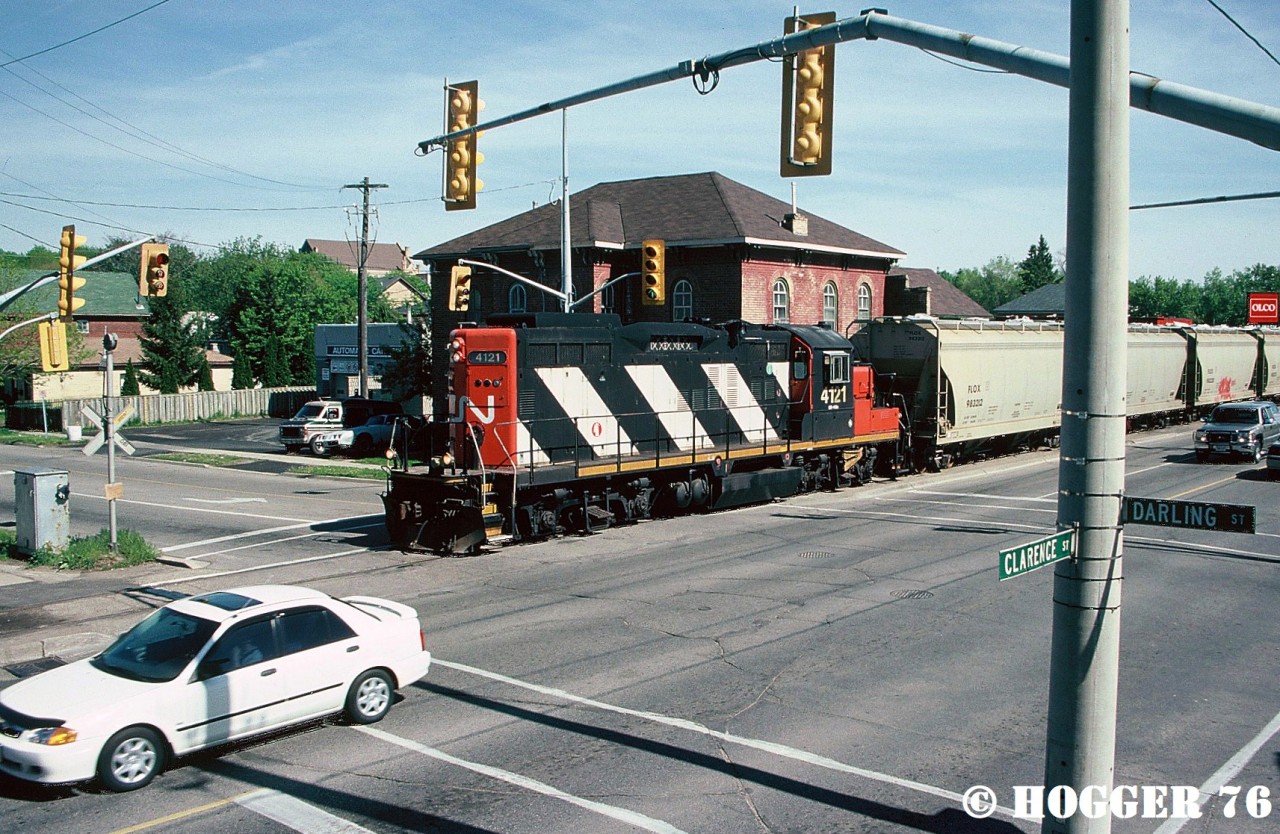 CN 580 with GP9RM 4121 is returning along the Burford Spur in Brantford, Ontario after working the SC Johnson & Son plant. The train is pictured crossing Darling Street where it intersects along the Clarence Street portion of the line.