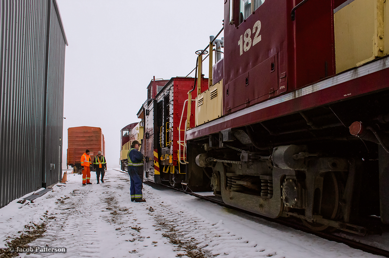 Back at the shop after being towed into town, shop staff have tied 1249 onto the nose of the plow to begin breaking up the consist, while Conductor Sheldon Golden (CAMI Job) confers with Plow Foreman Jack Hyde at left about the days events.  Once inside, crews would begin working on 182 to diagnose the issue at hand.