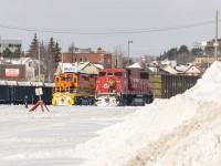 After a couple of days of snowfall, Huron Central power (OVR units 3410 and 2118) are soaking up the afternoon sun. Meanwhile, a rare-ish CP SD60M appears beside one of Sudbury's many large snowbanks. Behind it all, a Canadian flag flaps in the winter breeze, two days after its 60th birthday.