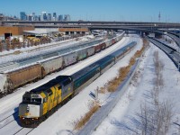 VIA 67 is passing grain cars with wrapped VIA 6420 leading. The grain cars closest to VIA 67 are about to be lifted by CN X400.