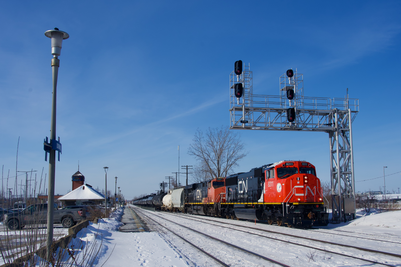 Rebuilt from an SD75I, CN 8311 leads CN 368 as it crosses over at Dorval. Faded CN 2297 trails.