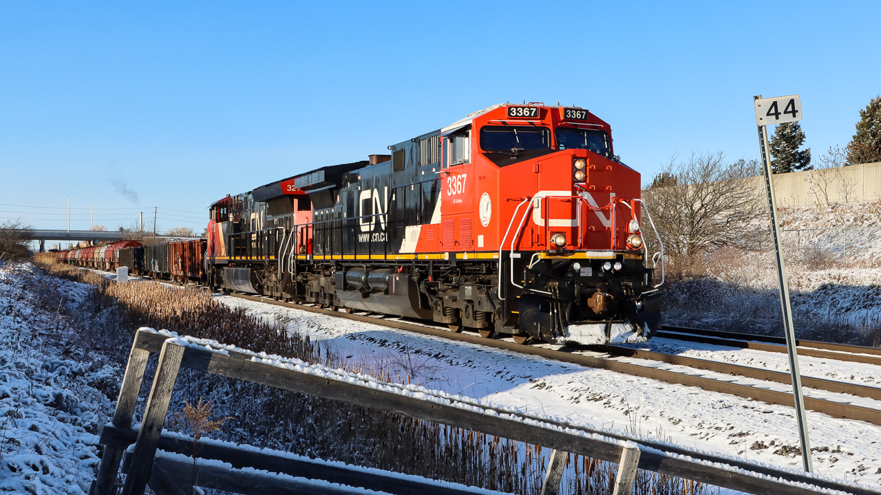 A westbound manifest train with a shiny rebuilt unit (ex-BNSF) in the lead passing Mile 44 Halton Sub..