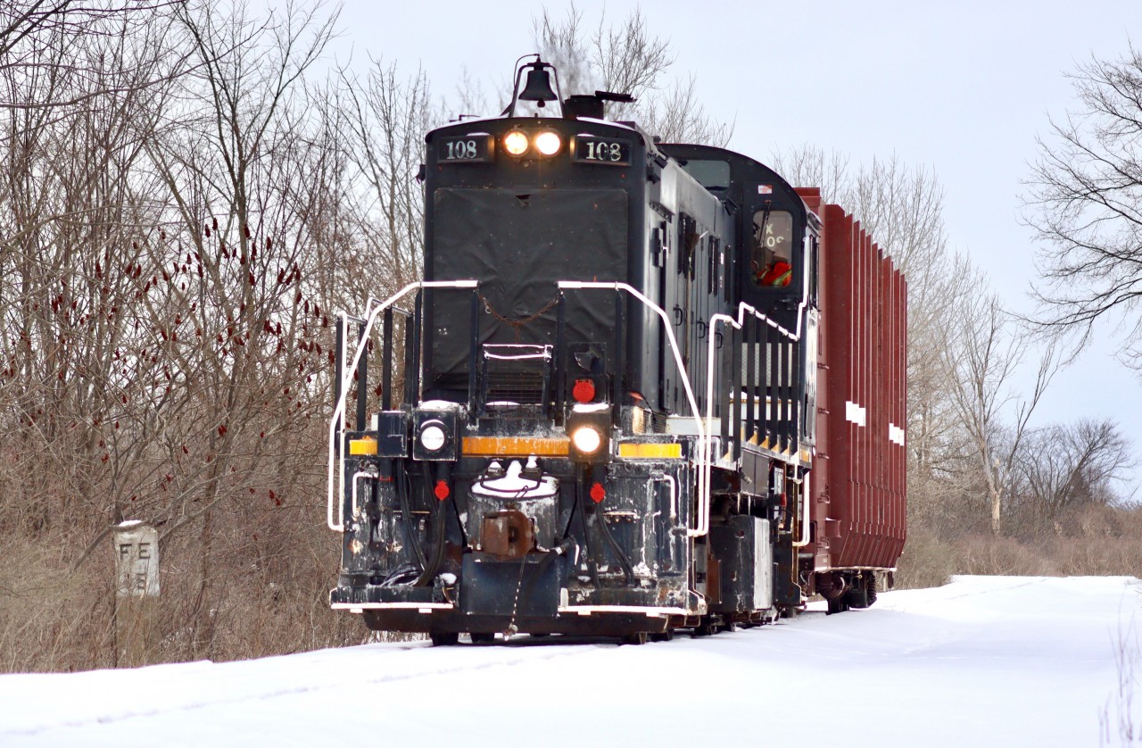 TR 108 is on its way back to Welded Tube after retrieving 1 empty pipe car from CN Southern Yard. Off to the left in the trees is an old stone mile-marker indicating 15 Miles to Fort Erie; apart of the former CASO that used to run along this right of way.