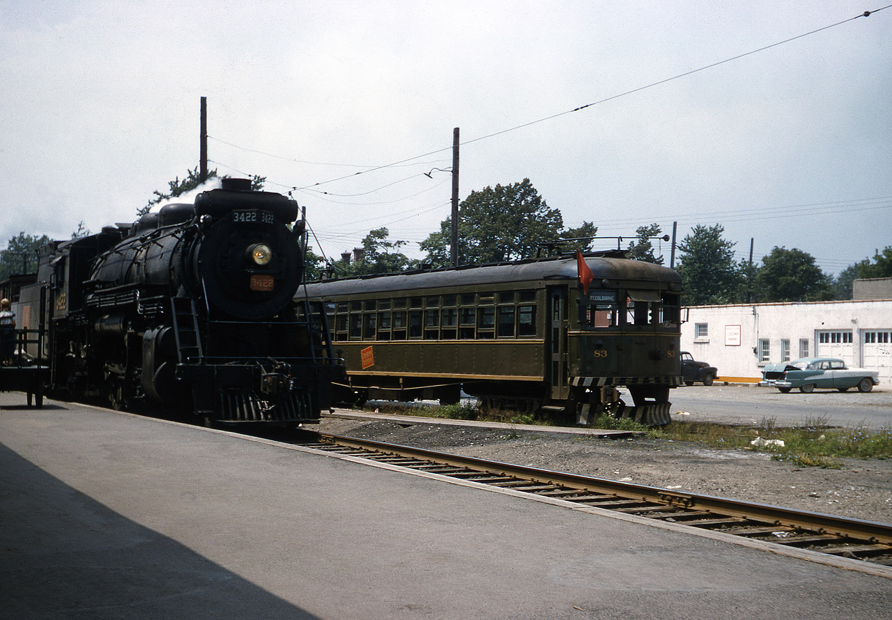 By the late 1950's it was clear that Steam's days were numbered, and Interurbans were almost non-existent.  The combination of the two may have been Roger Bloomquist's inspiration to travel from Indiana to Port Colborne to capture Mikado 3422 and NS&T 83 in this idyllic scene.  The building in behind is the local CTC (Canadian Tire) downtown location that was on site until the mid-80's.  The view is looking west, 3422 is traveling east bound on the Dunnville Sub, likely on the afternoon scheduled Stratford - Fort Erie run.  The NS&T has less than 2 years of Thorold to Port Colborne service left.  TH&B GP-7's were active here at that time... imagine a photo with a Maroon & Cream Diesel and you would have the Trifecta !  Thanks to Steve H for help here.