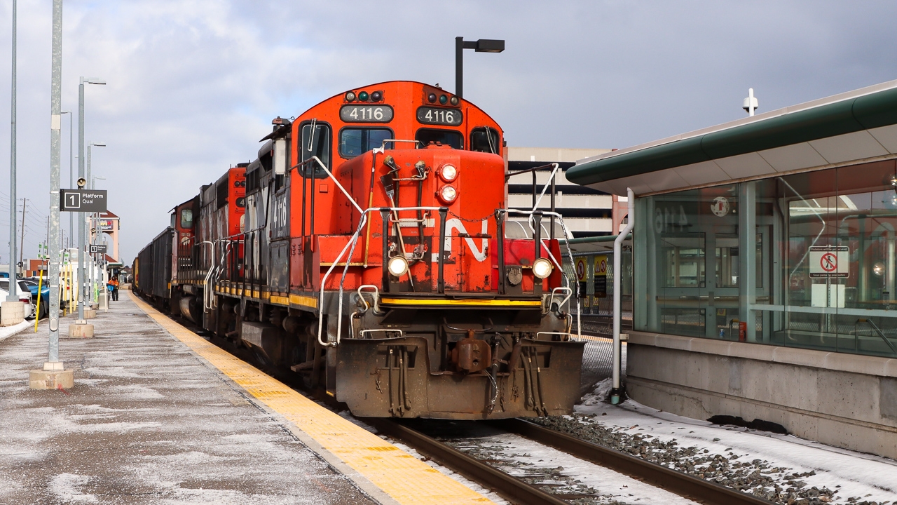 With their train stretching back to Oakville Yard on Track 1, L554 with veteran CN 4116 leading moves slowly through Oakville GO station heading toward Aldershot. Once the tail end clears Oakville Yard the throttle will get pulled back and they will be on their way.