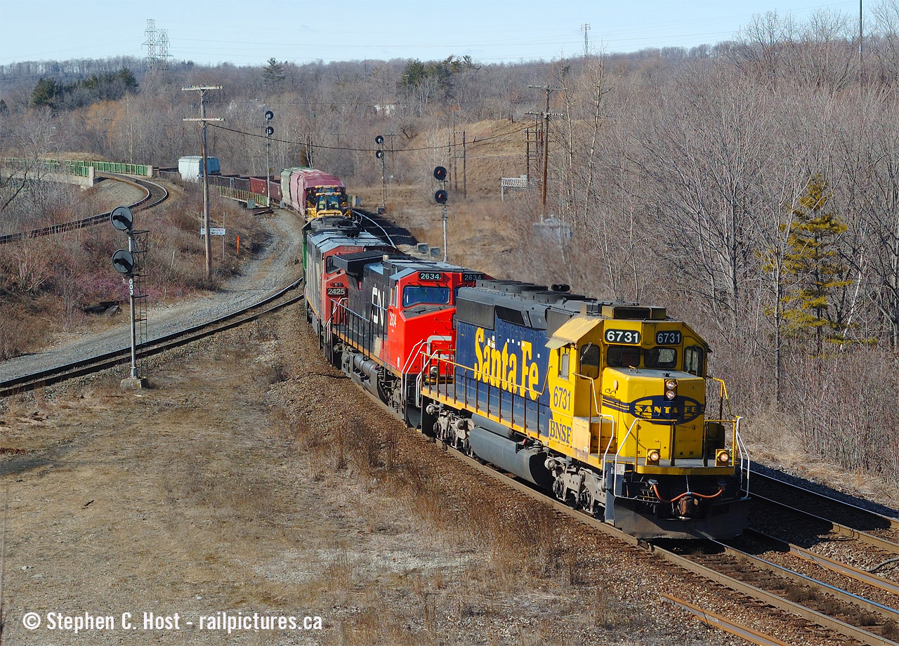 Such was the scene at Hamilton West in 2006. Searchlight signals everywhere, about two trains every hour on average, and on this day I photographed 11 moving trains in 5 hours, starting with NS 328 at Parkdale at 0837. After this I went home.
CN's bought some of the four axle BNSF fleet in all manner of paint schemes. Question for your BNSF fans, do any of these exist as four axle active on BNSF still? I know shortlines have these all over the place. Anyway, this was back in the Foreign Power days of CN, check this account by Arnold Mooney for the day's activities and a tip of the hat to Mr. Mooney for posting as I don't take many notes and his notes filled in info I used for this caption. I would shoot 3 in this scheme in 3 months in 2006 in Ontario. We also didn't chase them - why would you when you had so much good stuff coming?