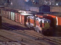 Algoma Central Railway GP7's 154 and 150, leased by CP Rail for a few months in 1978-79, handle CP's Cobourg Turn from Toronto as they switch cuts of cars in the small yard west of Ritson Road South in Oshawa.
<br><br>
It's hard to make out, but CN's former Oshawa Railway line runs north across the top of the image, perpendicular to CP's line (and crossing it <a href=http://www.railpictures.ca/?attachment_id=47602><b>at a diamond</b></a>). The small CP yard here served as the interchange between CP and CN, that helped feed boxcars full of auto parts coming off CP to the GM automotive assembly plants in the north end of the city along the Oshawa Railway <a href=http://www.railpictures.ca/?attachment_id=44197><b>switched by CN</b></a> (there was a CN restriction that didn't permit cars longer than 52'6" unless authorized, and 60' cars permitted for only a few sidings). 50' boxcars from Santa Fe, Southern, DT&I, N&W, CP, CP and C&O/B&O are visible, likely carrying automotive components originating at assembly plants in different parts of North America.
<br><br>
<i>Keith Hansen photo, Dan Dell'Unto collection slide.</i>
<br><br>
A more modern view after CN's Oshawa Railway operations ended: <a href=http://www.railpictures.ca/?attachment_id=23535><b>http://www.railpictures.ca/?attachment_id=23535</b></a>