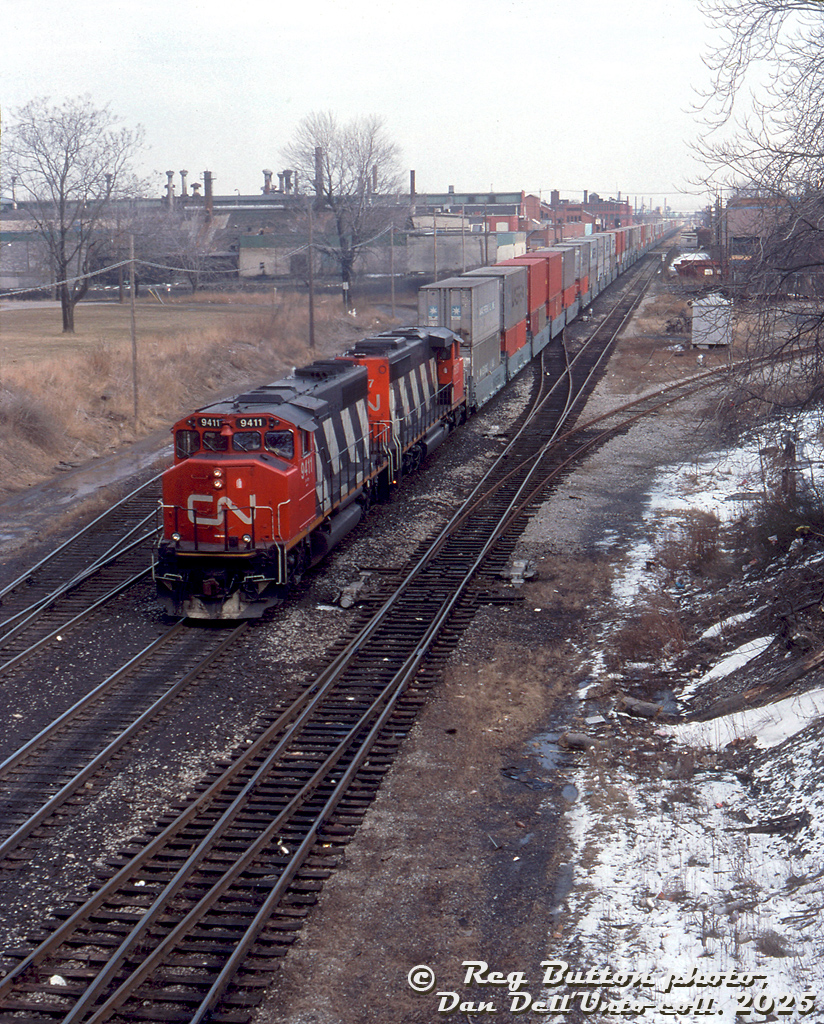 CN GP40-2L(W) 9411 and SD40-2W 5357 lead an intermodal train on the CN Grimsby Sub through Hamilton, passing Ferguson Avenue where the Hagersville Sub and N&NW Spur branch off the mainline.

Reg Button photo, Dan Dell'Unto collection slide.