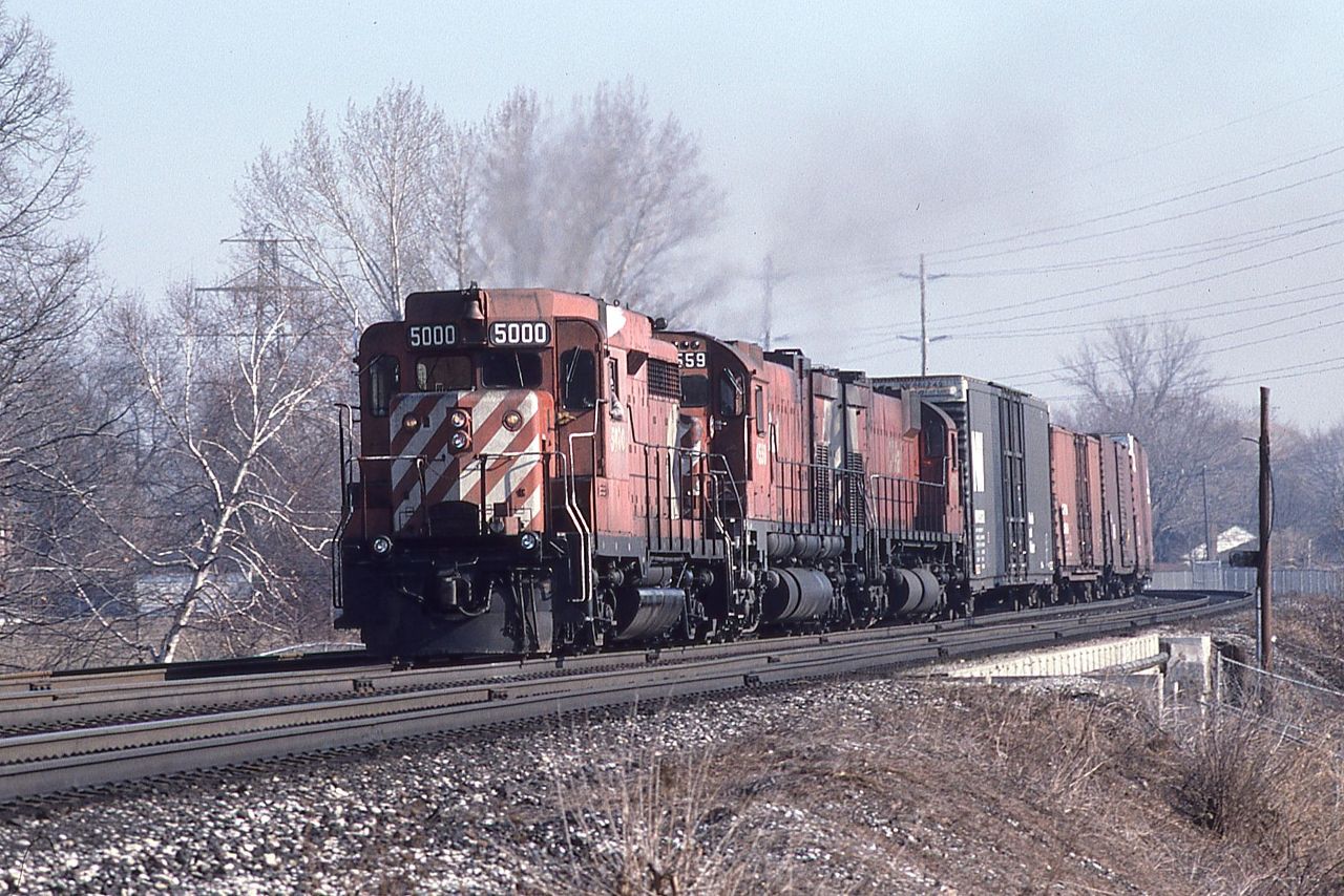 CP GP30 5000 leads a pair of C630s, 4559 and 4562, west over what possibly could be Islington Avenue on March 7th, 1987.  The city may have encroached on this location a little in the 38 years since the photo was taken. I did not like chasing trains this time of year; the days were warmer, longer, and inviting, but nothing was green yet.