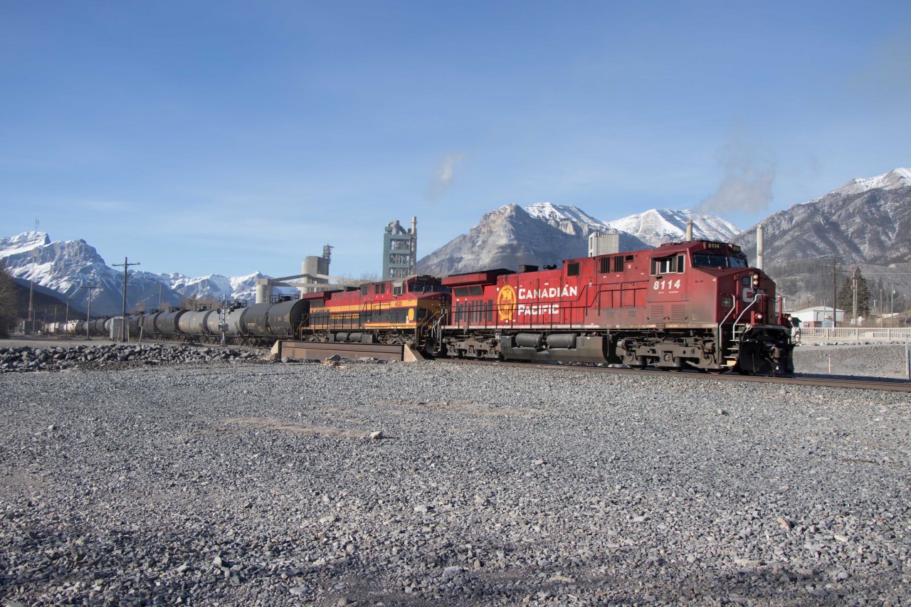 Aided by howling west winds, CPKC200 (Coquitlam-Clover Bar, AB) rolls through Exshaw behind AC4400CWM 8114, KCS AC4400 4620 and mid-train DPU KCS 4617.