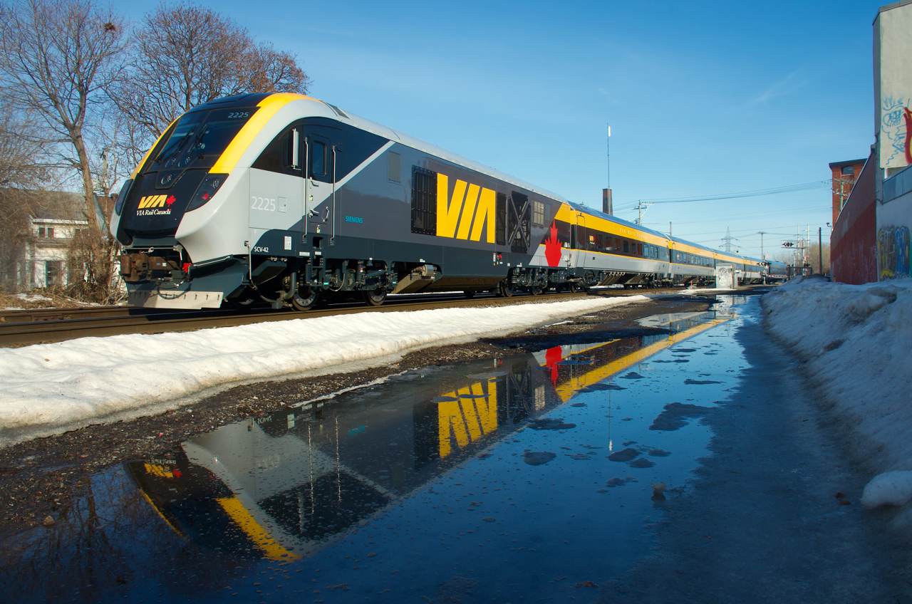 Entering in revenue service during the last week or so, the third newest Siemens consist is reflected in some water as it heads east.